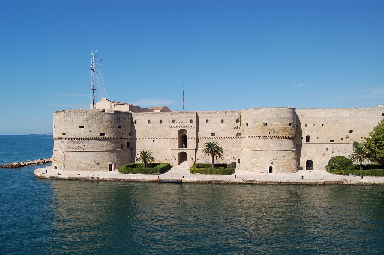 Vista panoramica del lungomare di Taranto con castello antico sullo sfondo.