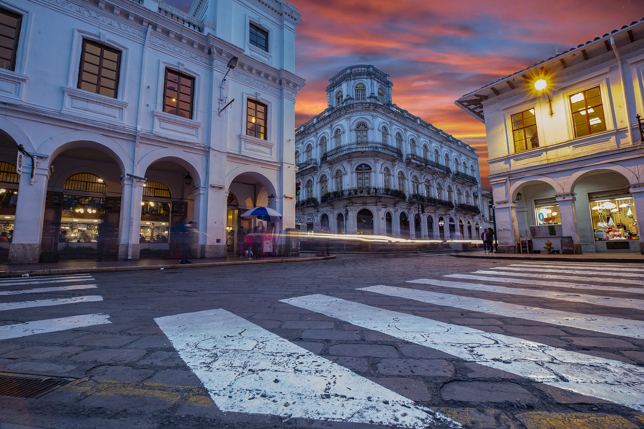 Turista che esplora un centro storico di sera, illuminato da luci calde e suggestive.