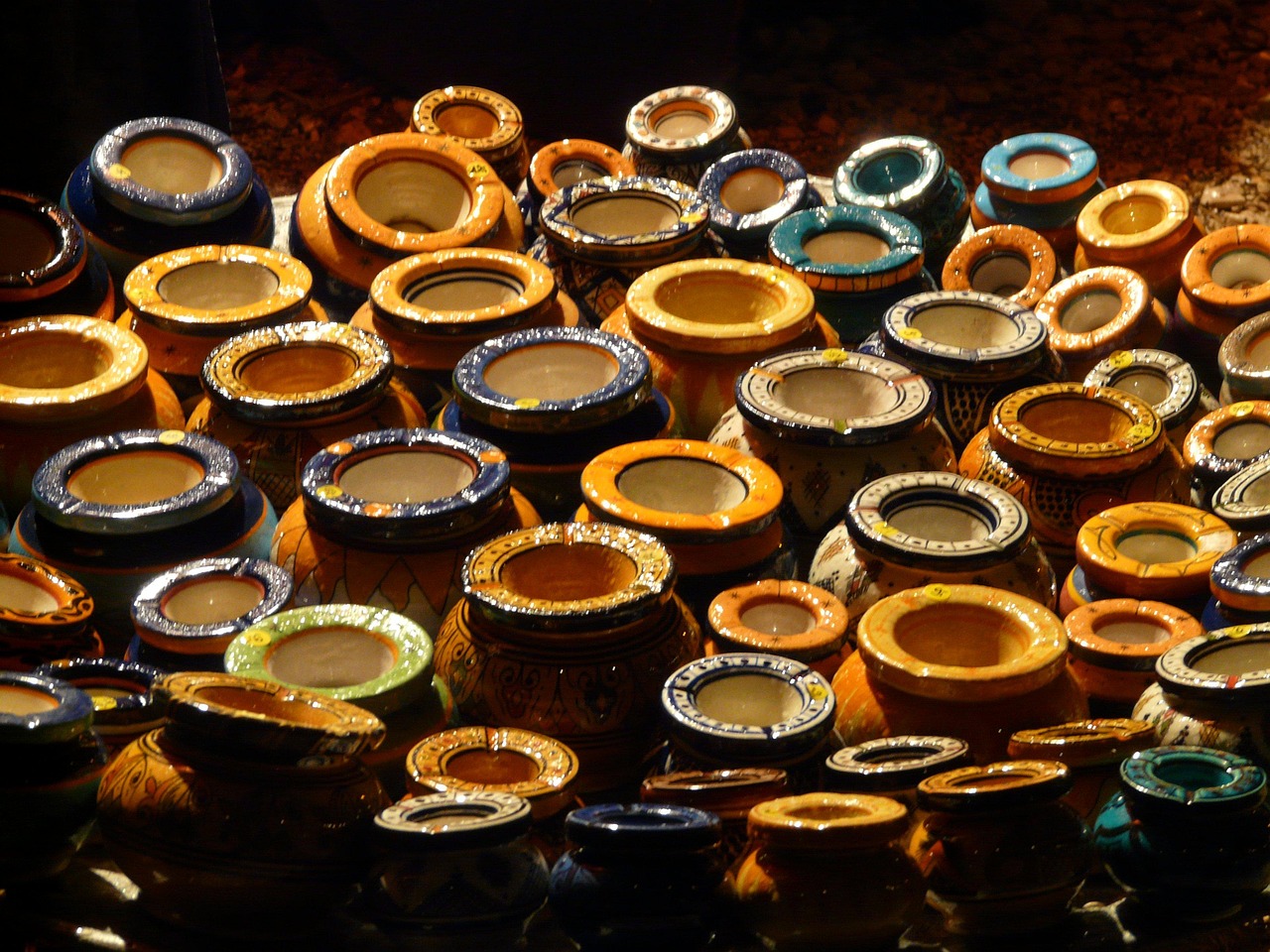 Borghi pittoreschi con artigiani che lavorano la ceramica, mostrando prodotti unici e colorati.