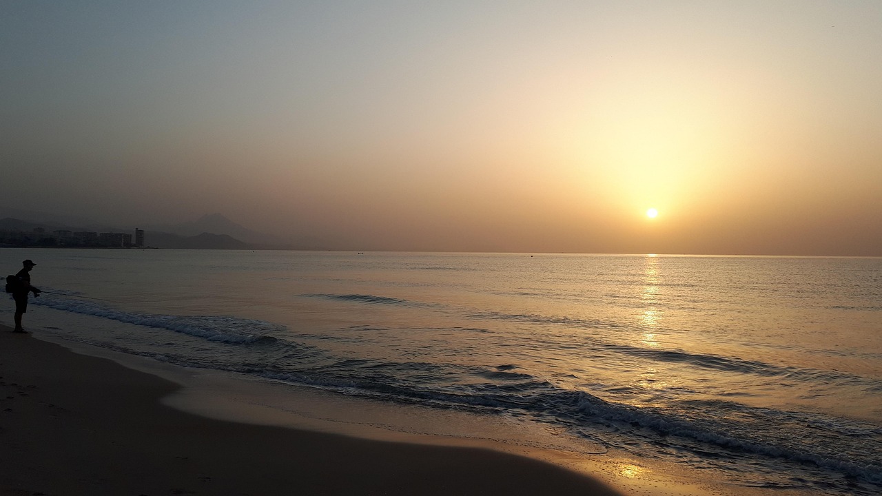 Spiaggia tranquilla al mattino con acqua bassa, ideale per passeggiate rilassanti.