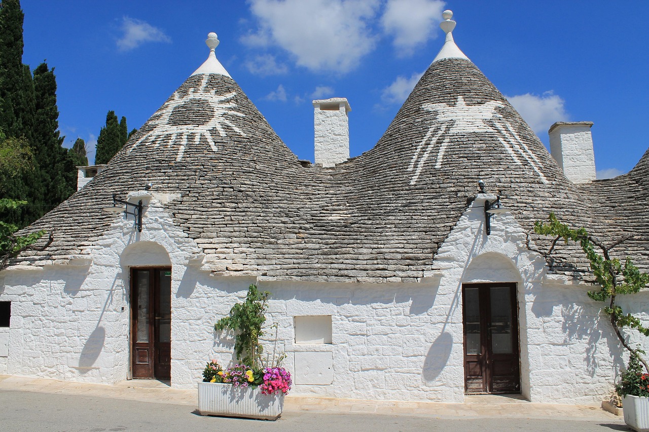 Vista panoramica di Alberobello con trulli e paesaggio tipico pugliese.