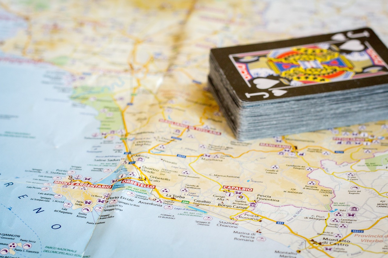 Turista che consulta una mappa cartacea mentre esplora un borgo antico.