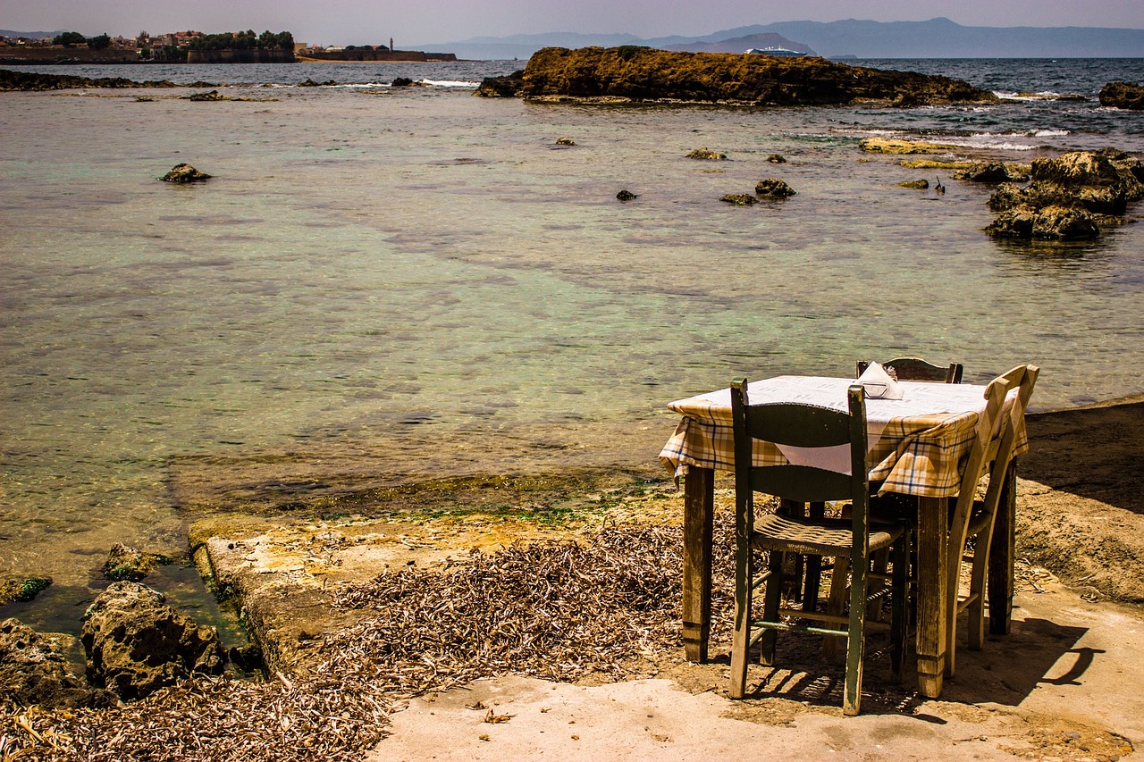 Spiaggia tranquilla con vista mare, ombrelloni e cestino da picnic su un prato verde.