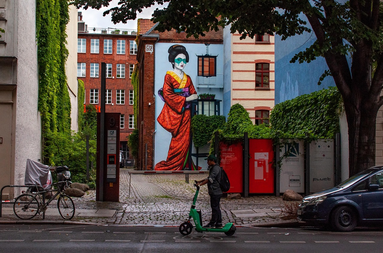 Murales colorati su un muro urbano, evidenziando l'arte di strada in una città vivace.