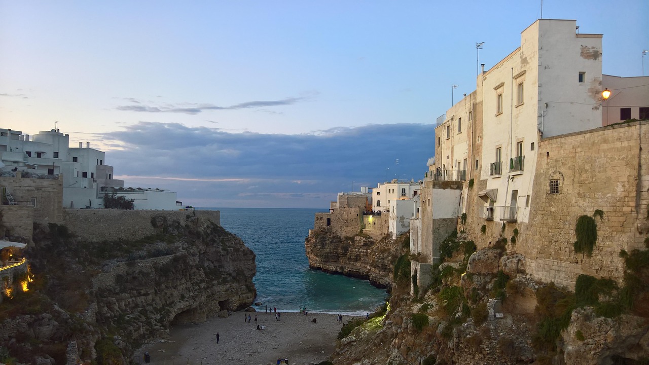 Vista panoramica di Polignano a Mare con case bianche e mare blu, ideale per scegliere l'alloggio.
