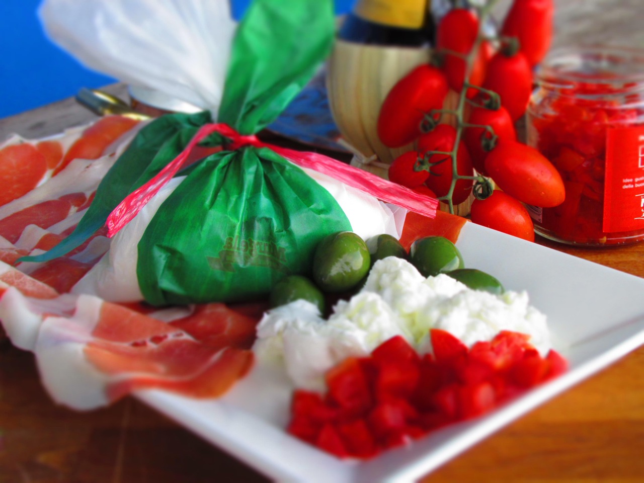 Burrata fresca servita in un tipico locale pugliese con pomodori e basilico.
