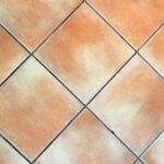 Fuga di piastrelle pulita con acqua ossigenata, evidenziando il metodo efficace per sbiancarle.