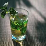 Tazza di tè alla menta con foglie fresche, simbolo di attenzione per la pressione sanguigna.