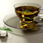 Tazza di tè verde fumante su un tavolo, simbolo di salute e benessere.