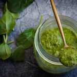 Barattolo di pesto con etichetta di avvertenza su ingredienti dannosi per cuore e fegato.