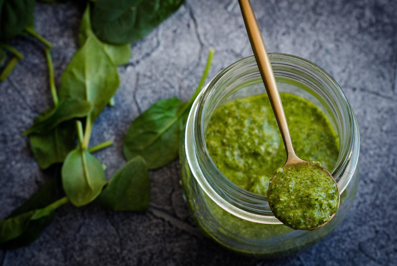 Barattolo di pesto con etichetta di avvertenza su ingredienti dannosi per cuore e fegato.