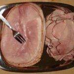 Immagine di un pacchetto di prosciutto cotto con etichetta evidenziata sugli effetti negativi per salute.