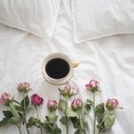 Immagine di una colazione romantica con fiori e caffè, simbolo di un dolce buongiorno.