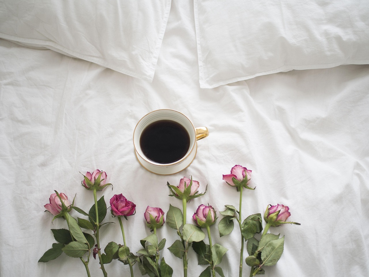 Immagine di una colazione romantica con fiori e caffè, simbolo di un dolce buongiorno.