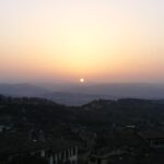 Borgo italiano sotto il sole estivo, con un cielo sereno che illumina il paesaggio per tre giorni.