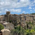 Borgo umbro con cinque torri identiche, simbolo di curiosità storica e architettonica italiana.