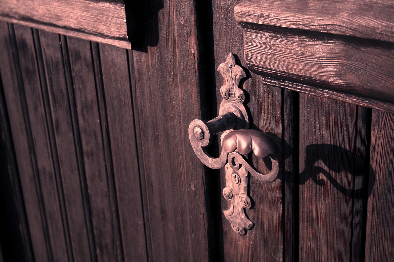 Maniglia di una porta con segni di usura e sporco, simbolo di zone poco igieniche in casa.